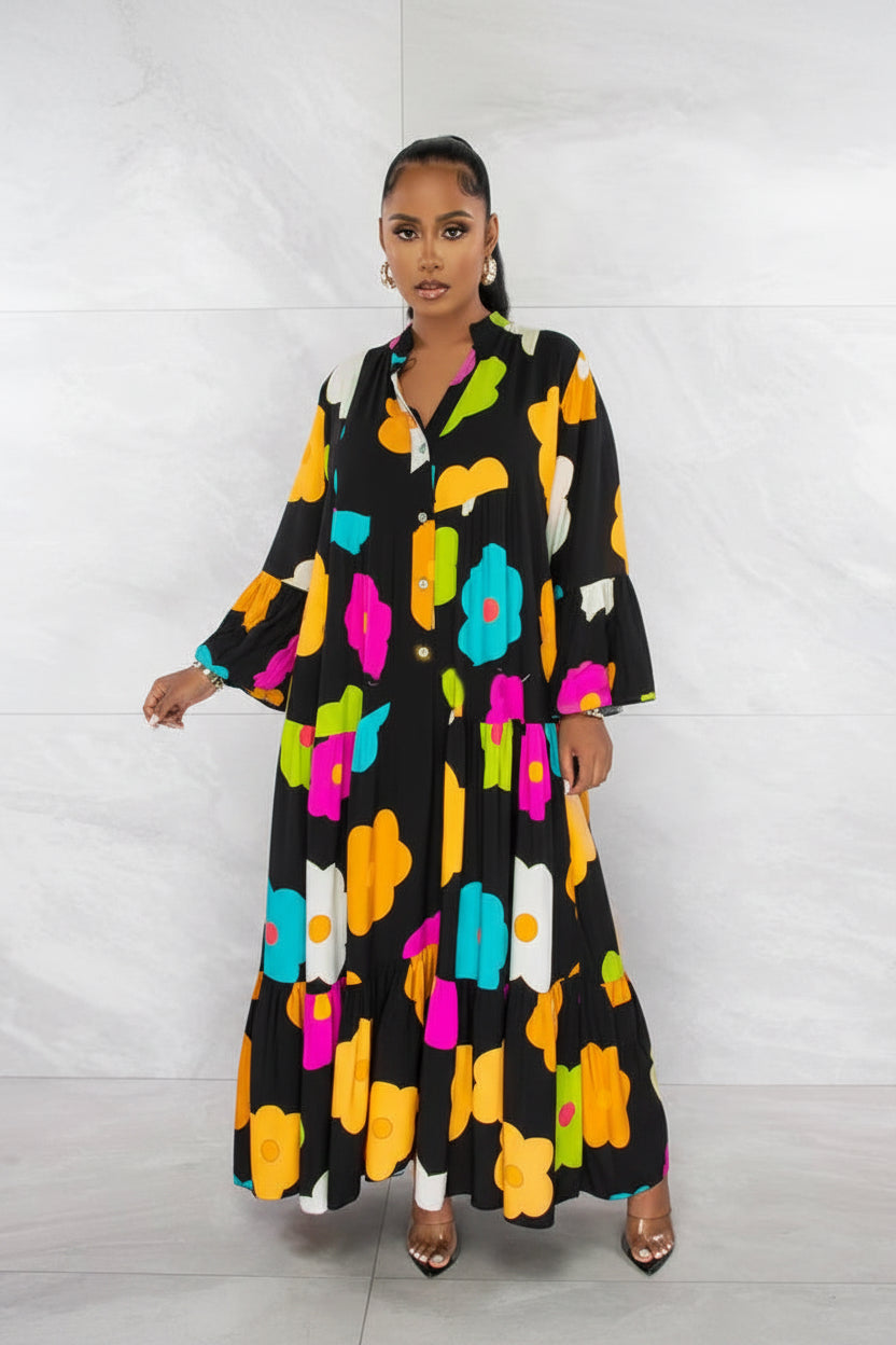 Woman wearing a black dress with colorful floral patterns against a white background