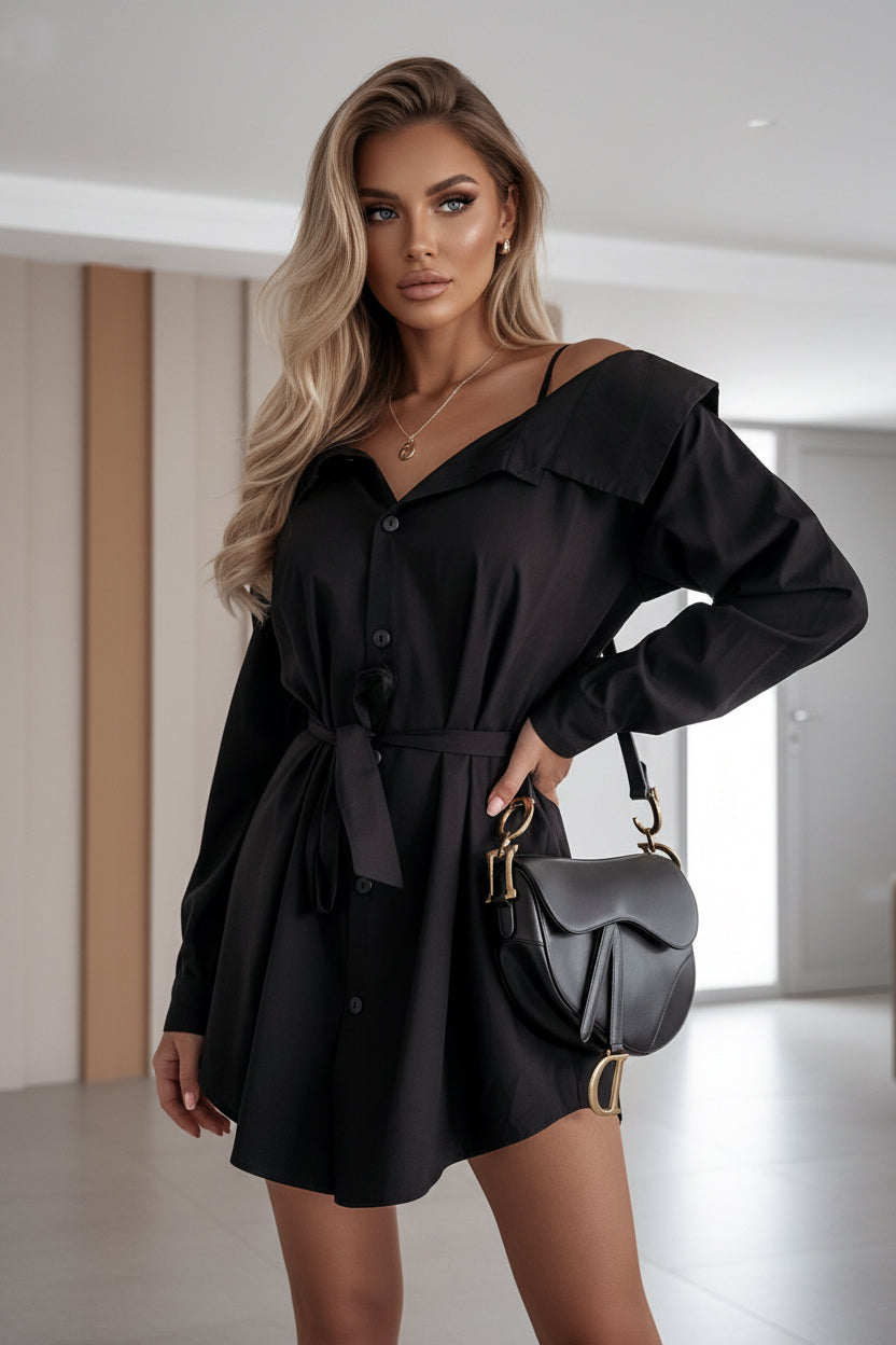 Person wearing a black off-shoulder dress with a matching handbag indoors.