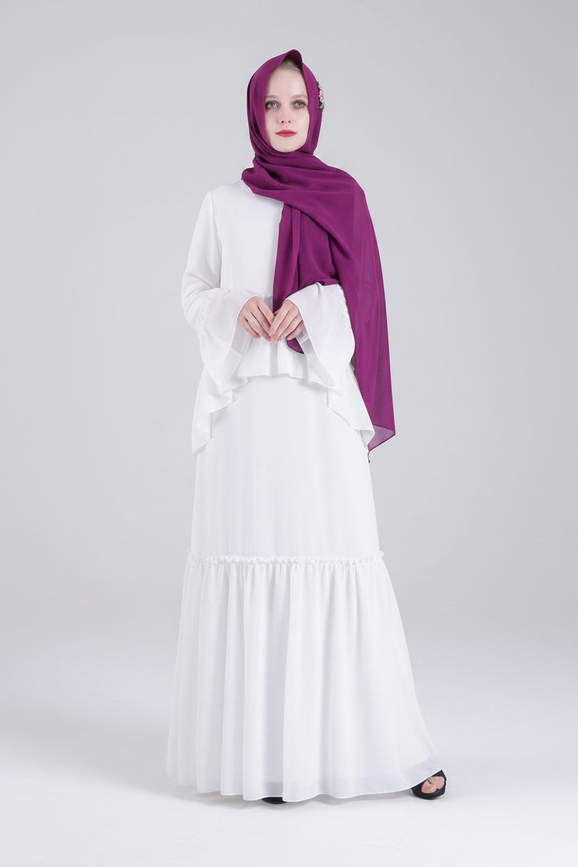 Woman wearing a white dress and purple hijab on a white background