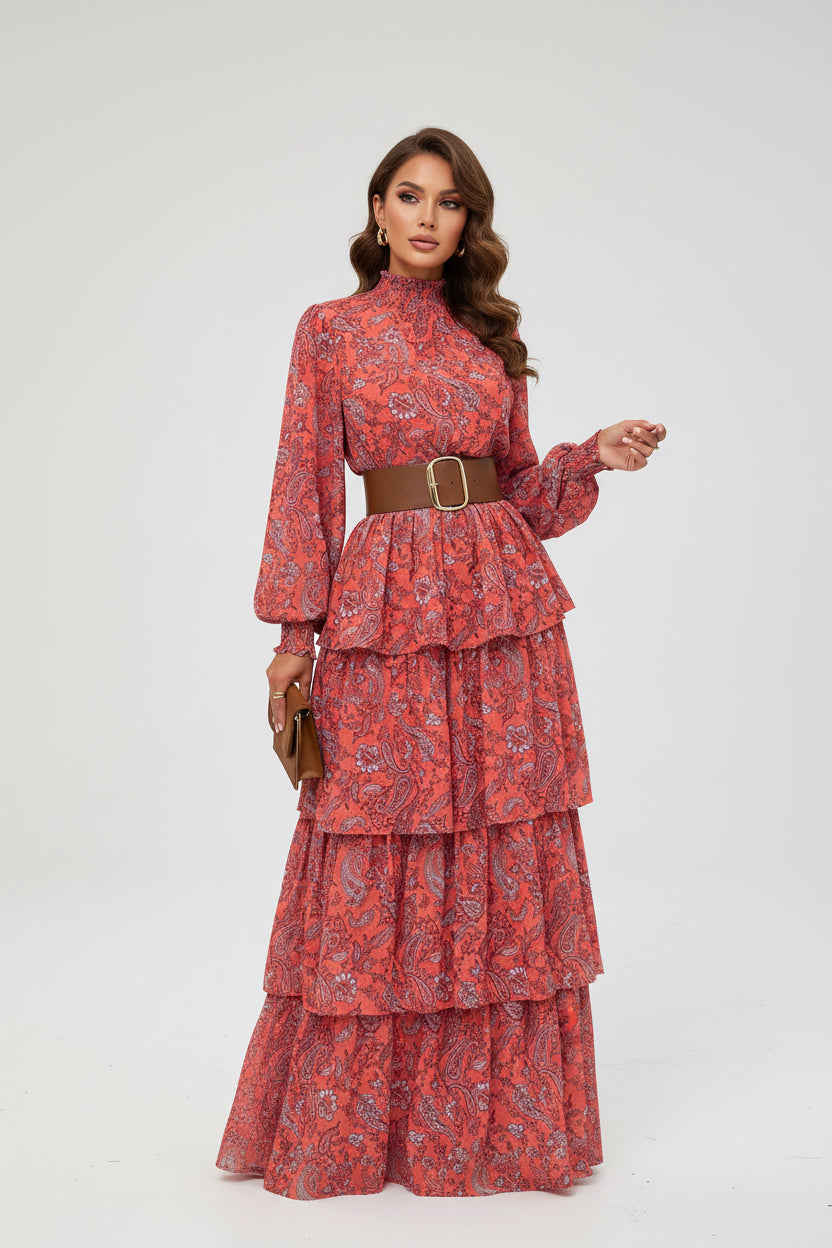 Person wearing a red patterned dress with a brown belt on a sidewalk.