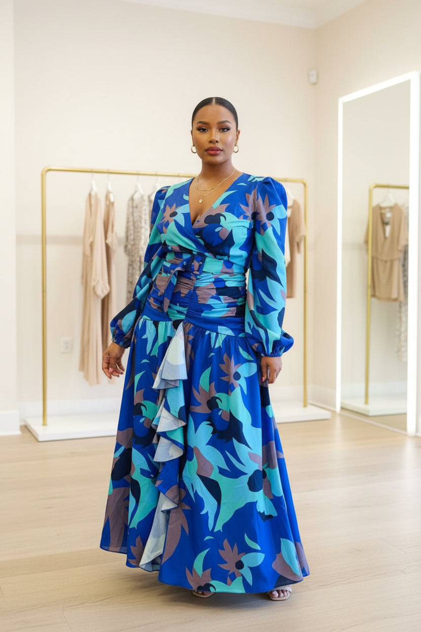 Woman wearing a blue floral dress standing in front of colorful fabric displays.