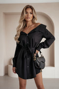 Person wearing a black off-shoulder dress with a matching handbag indoors.