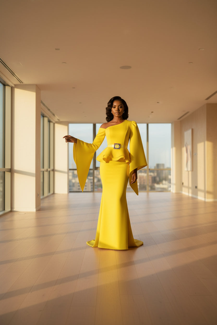 Yellow one-shoulder top with a colorful square design on a mannequin against a dark curtain background.