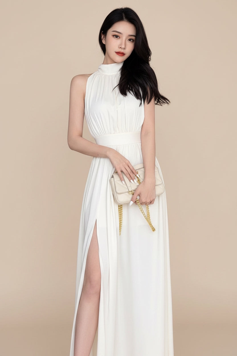 Woman in a white dress holding a matching handbag in an indoor setting.