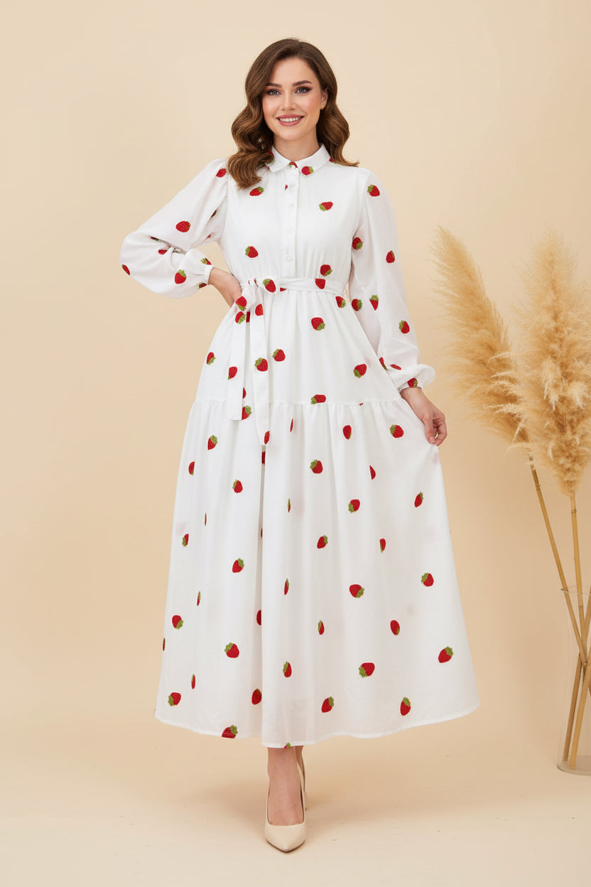 White dress with red polka dots worn by a person against a plain background
