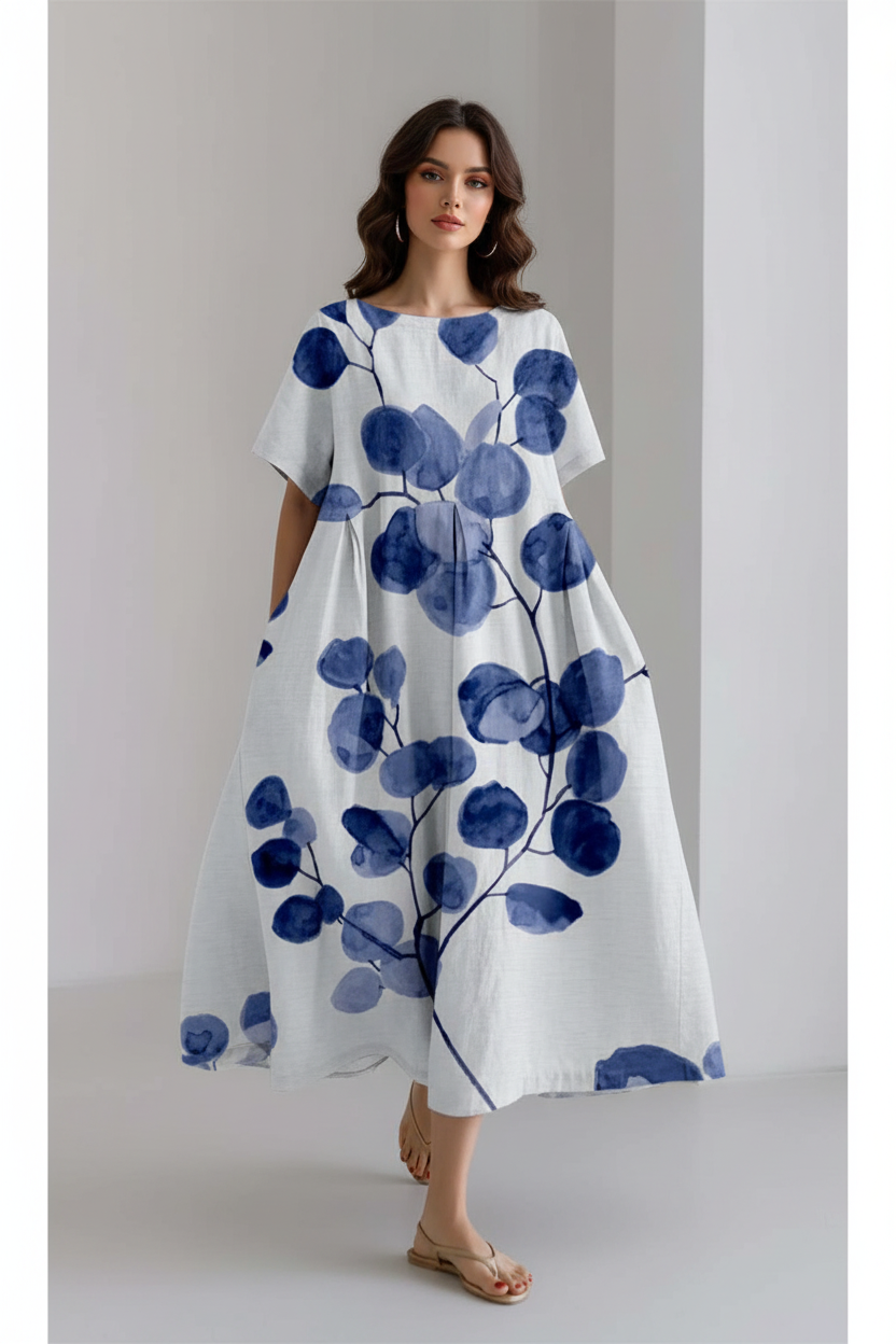 White dress with blue floral pattern worn by a person on a plain background