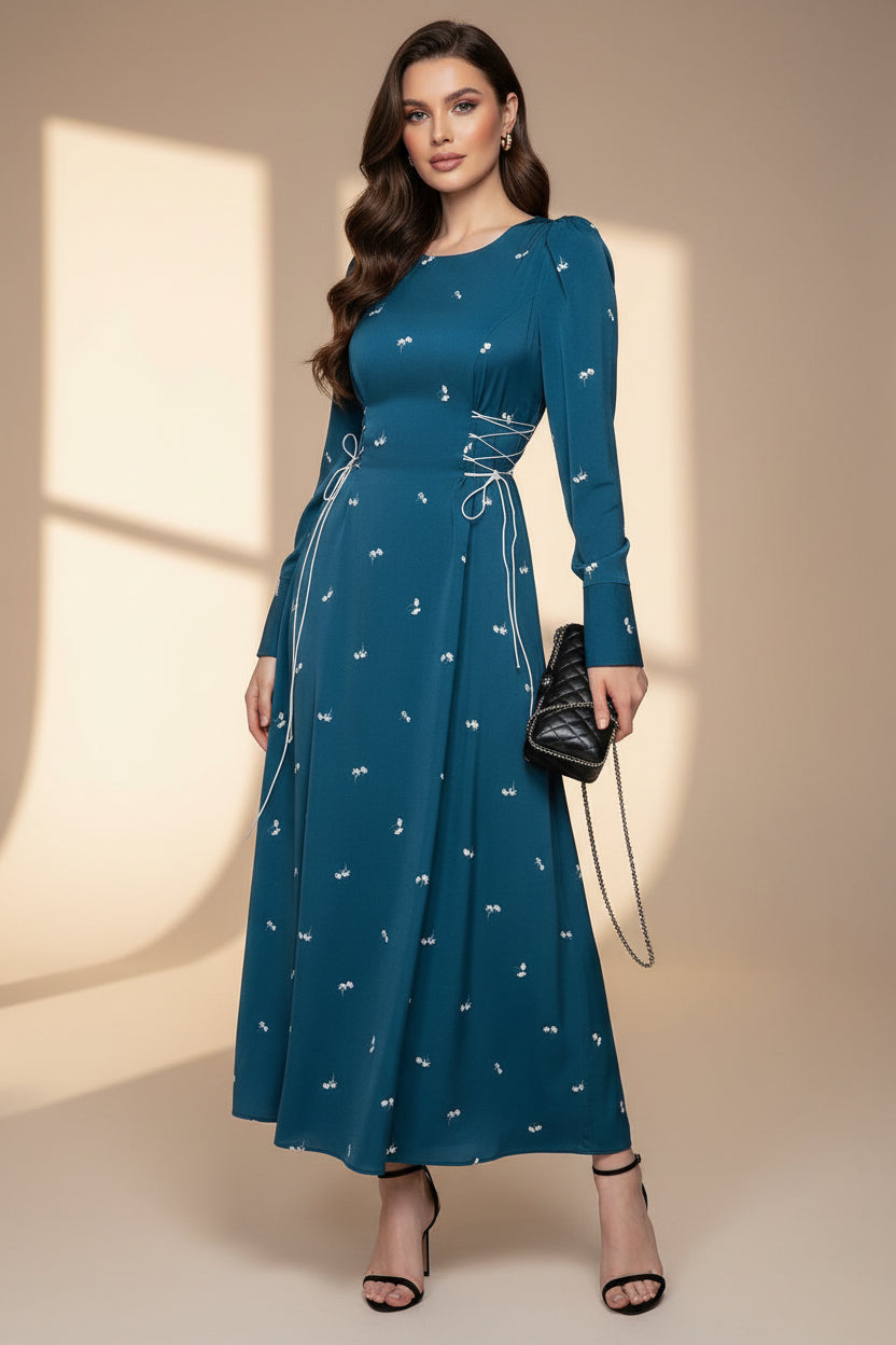 Woman wearing a blue dress with white patterns against a neutral background