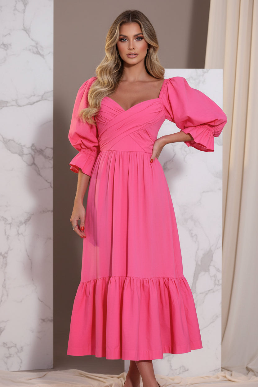 Woman wearing a bright pink dress with puffed sleeves in an outdoor setting.