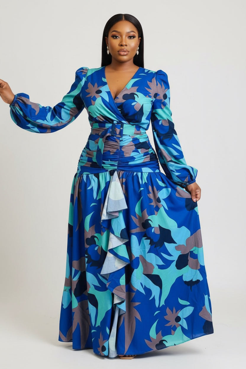 Woman wearing a blue floral dress standing in front of colorful fabric displays.