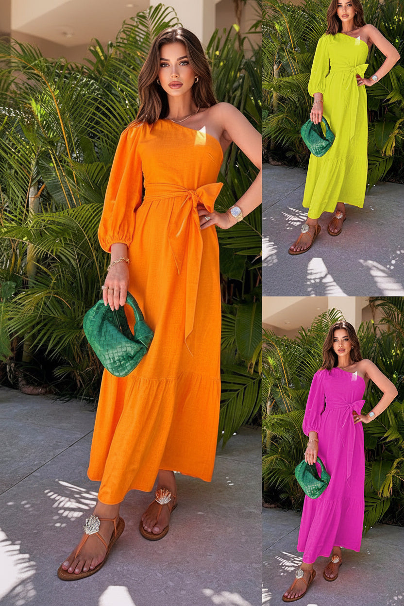 Three women in different colored dresses holding a green handbag with a tropical background.