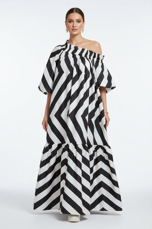 Woman wearing a black and white striped dress on a street.