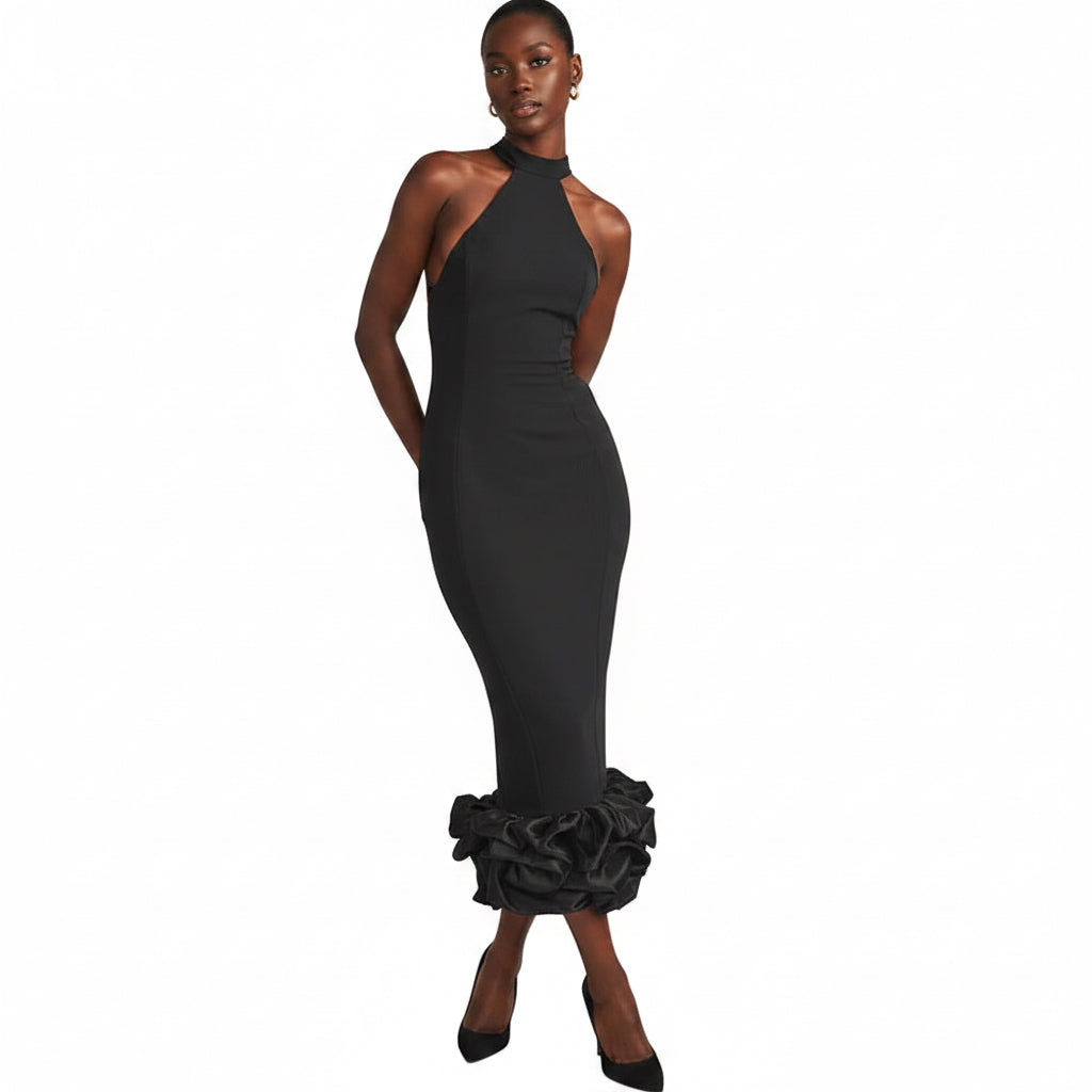 Woman wearing a black dress with ruffled bottom section on a beige background