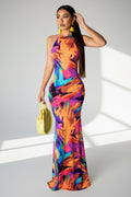 Woman wearing a colorful floral dress holding a yellow handbag on a white background