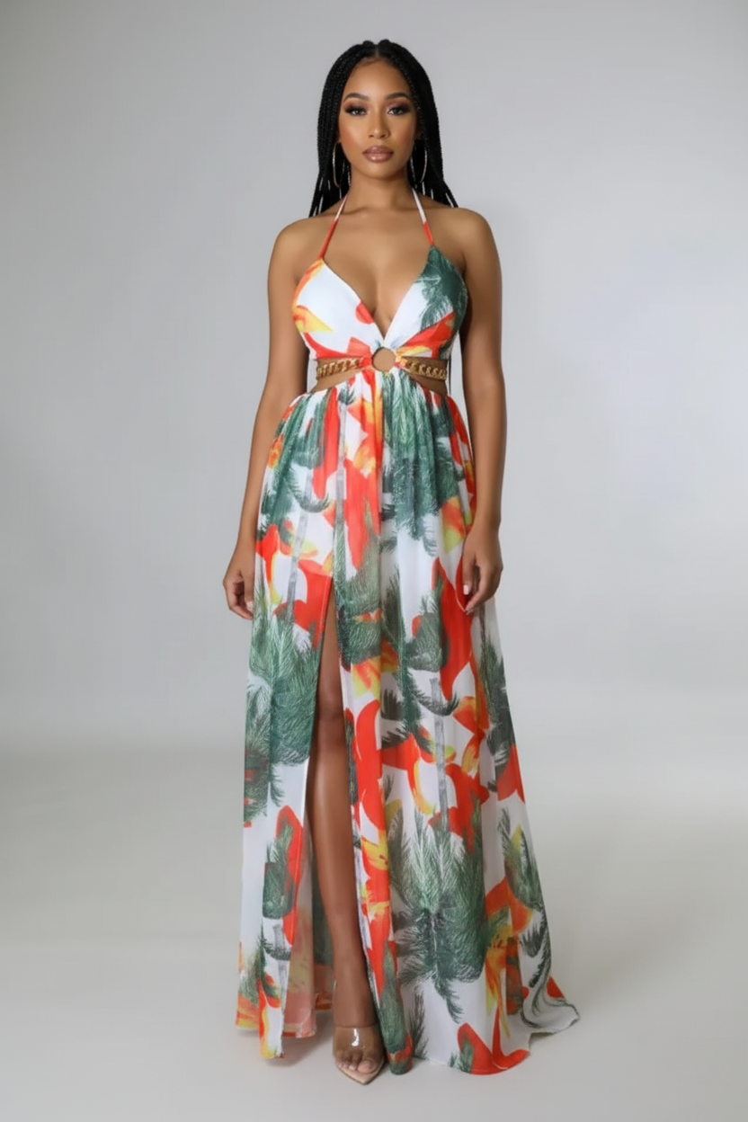Woman wearing a colorful floral dress with a high slit on a plain background
