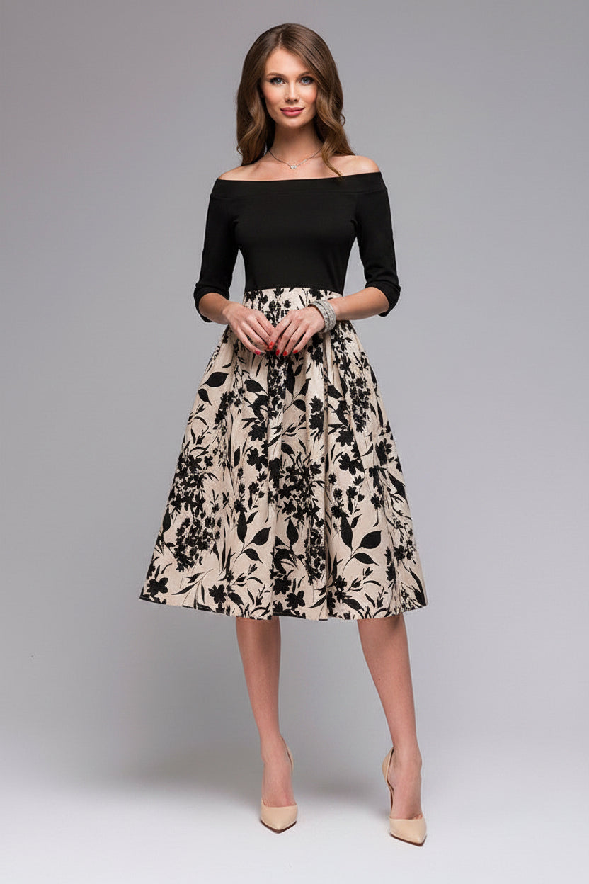 Woman wearing a black top and floral skirt on a gray background