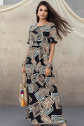 Woman wearing a black and white patterned dress holding a round straw bag.