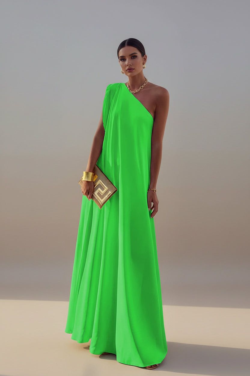 Person wearing a bright green one-shoulder dress with a scenic background