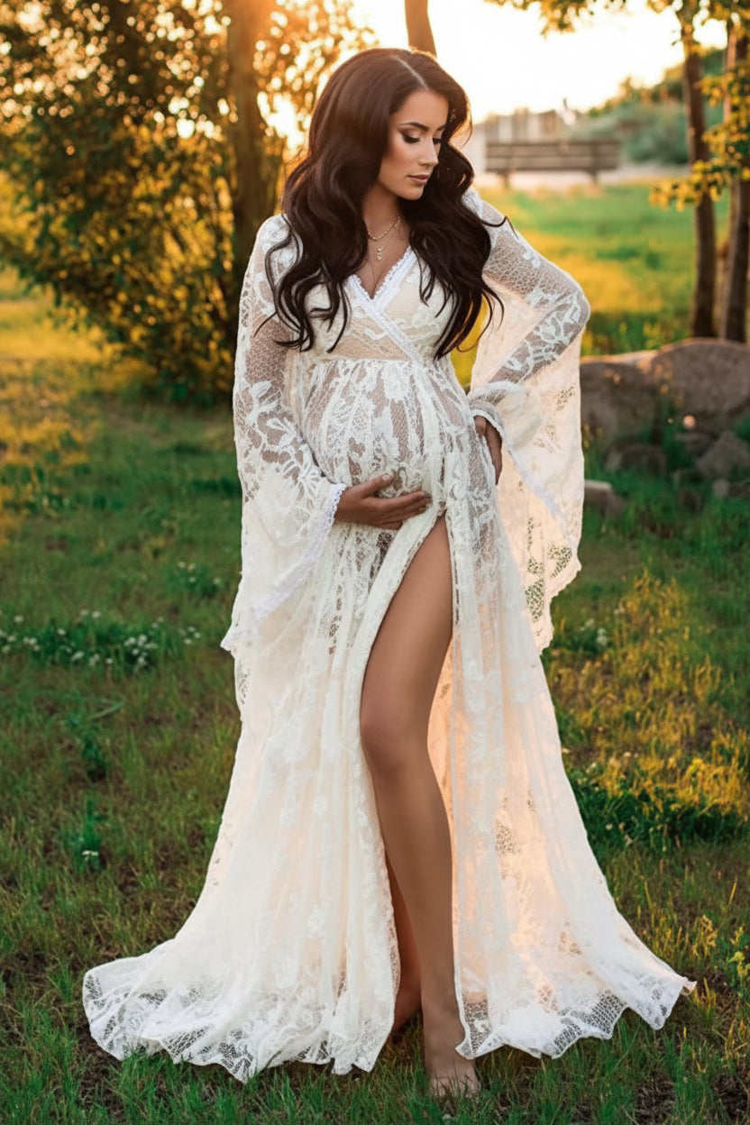 Woman in a white lace dress standing in a field with trees in the background