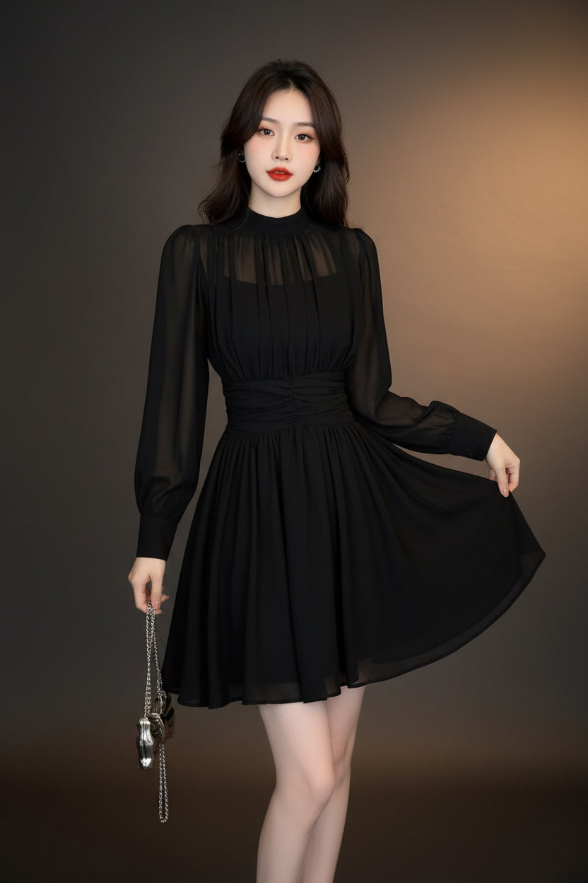 Woman wearing a black dress standing in a room with a door and wall.