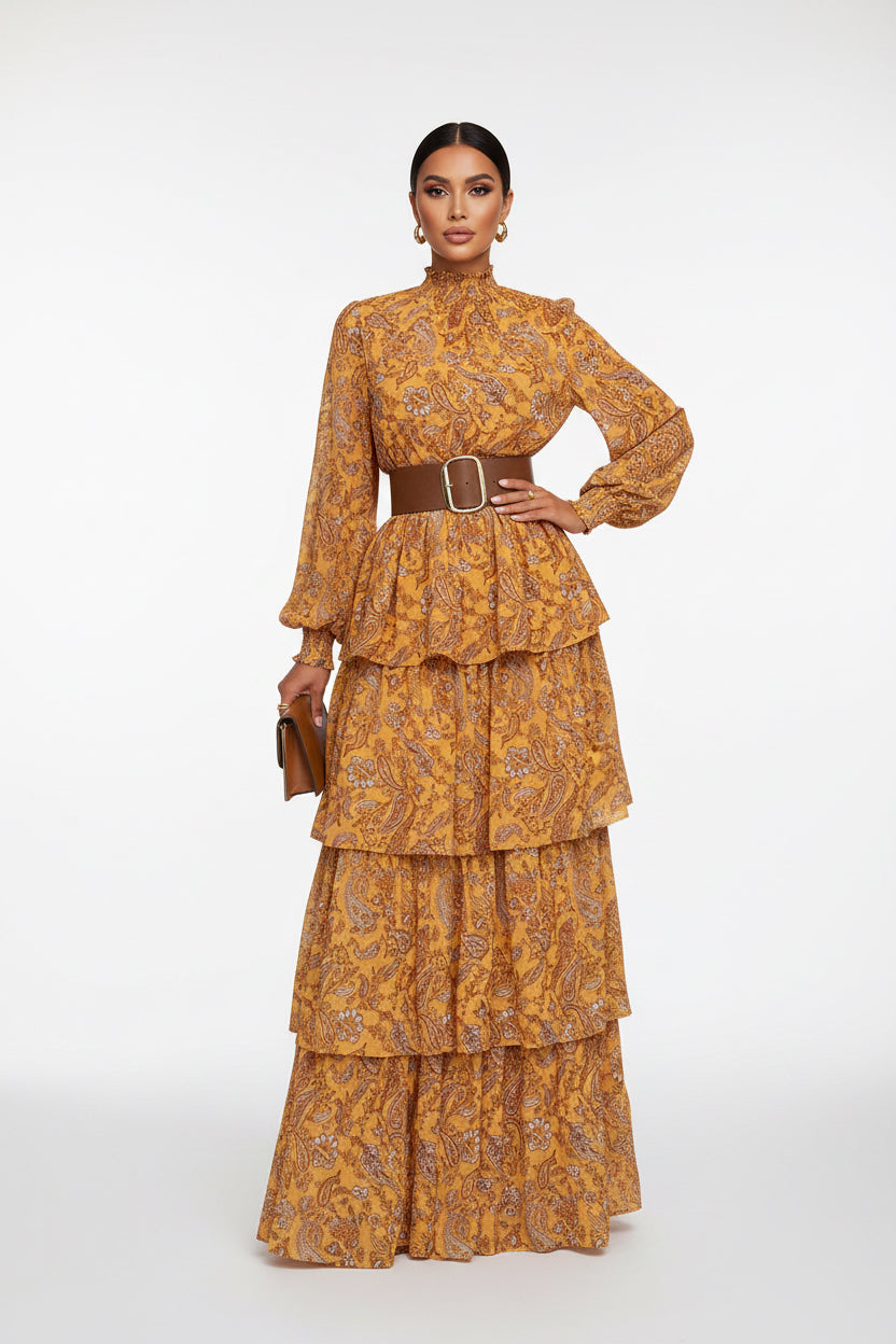Person wearing a yellow floral dress with a brown belt on a sidewalk.