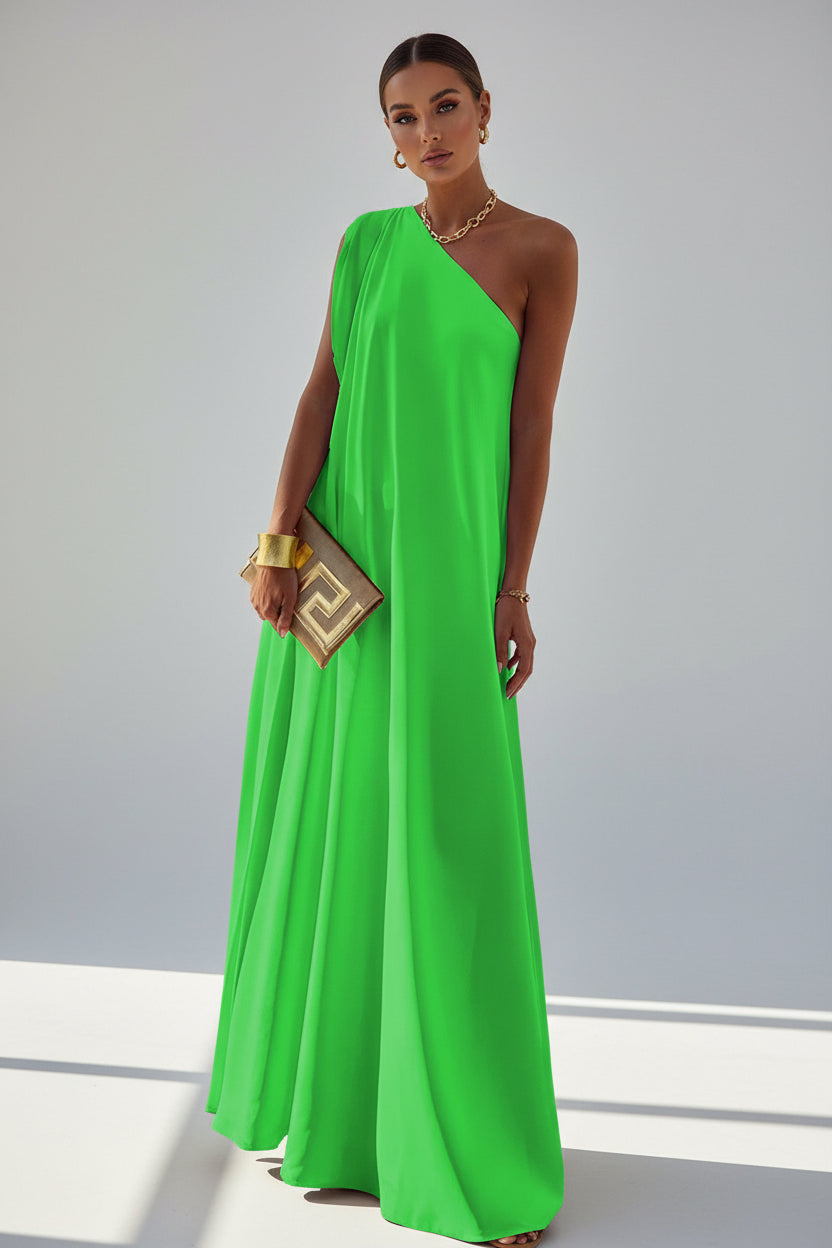 Person wearing a bright green one-shoulder dress with a scenic background