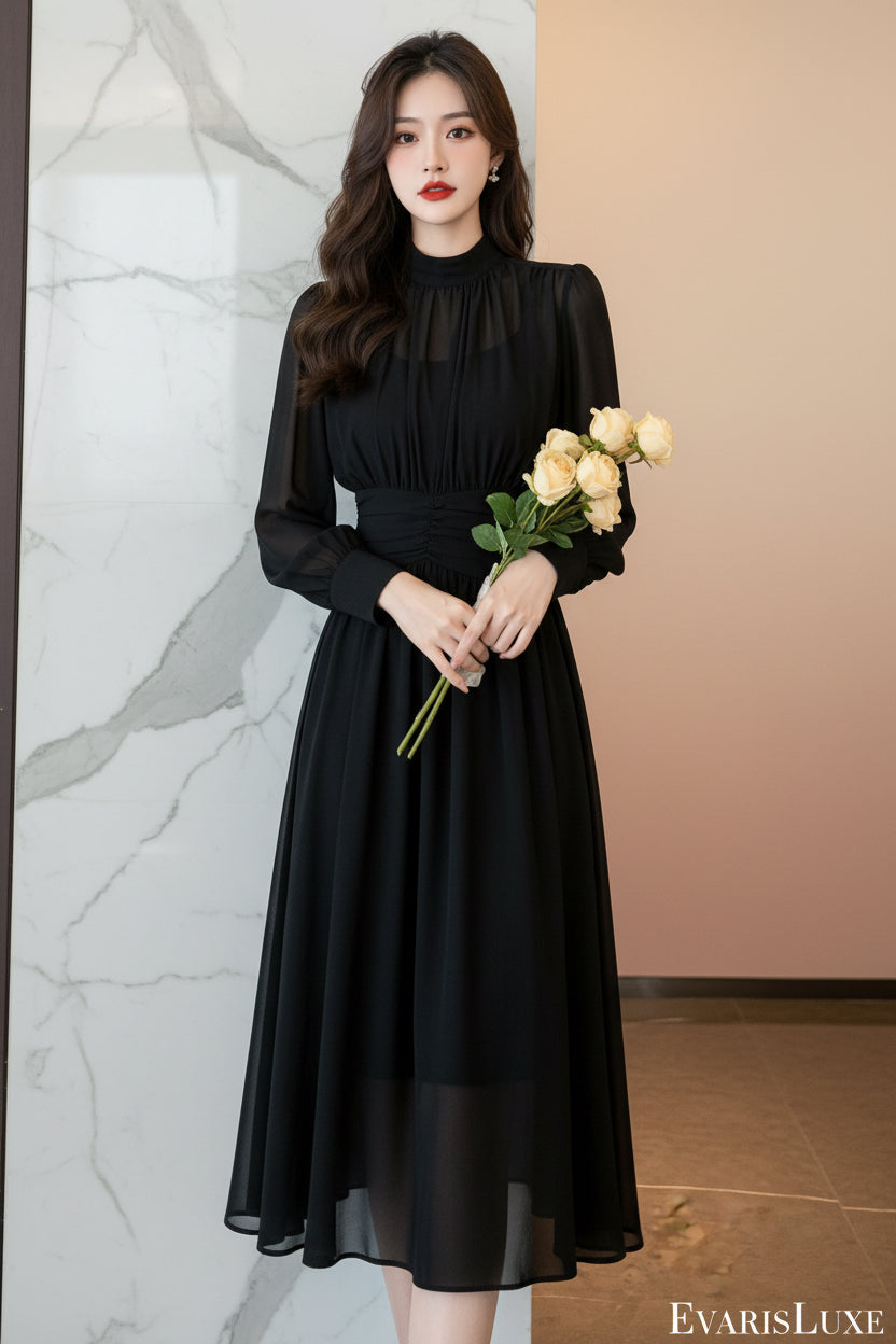 Woman in a black dress holding flowers in a kitchen.