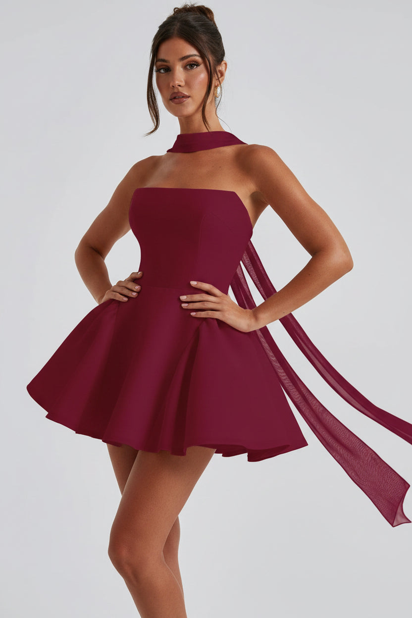 Woman wearing a burgundy dress against a plain background