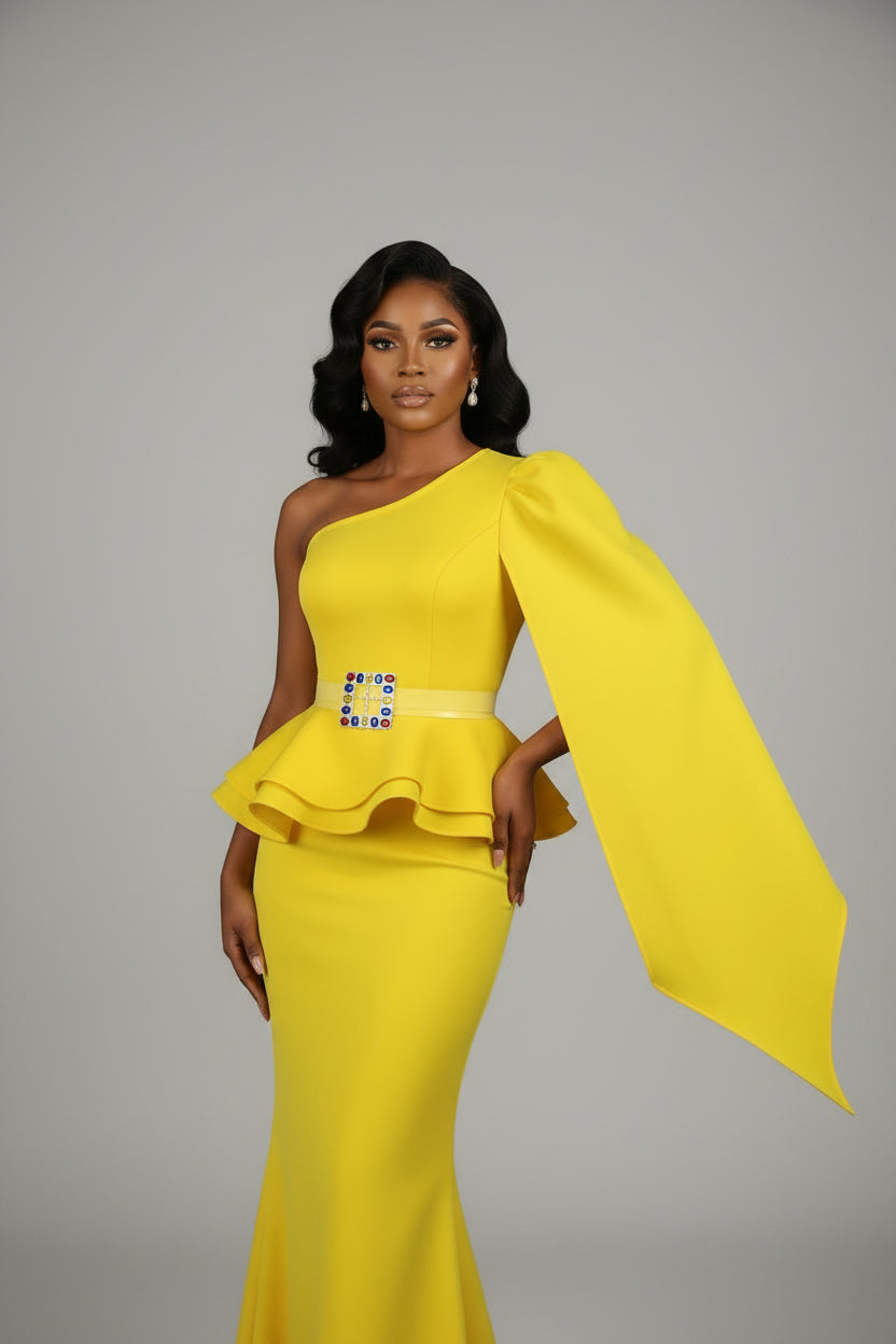 Yellow one-shoulder top with a colorful square design on a mannequin against a dark curtain background.