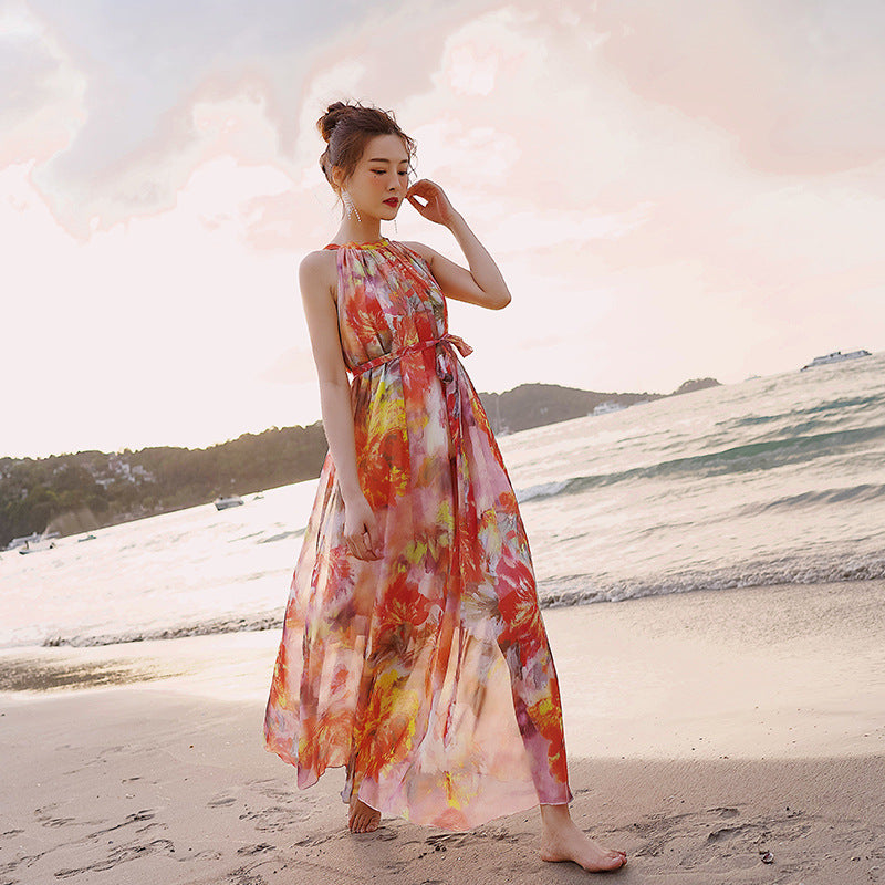 Woman in a colorful dress standing on a beach with a scenic background