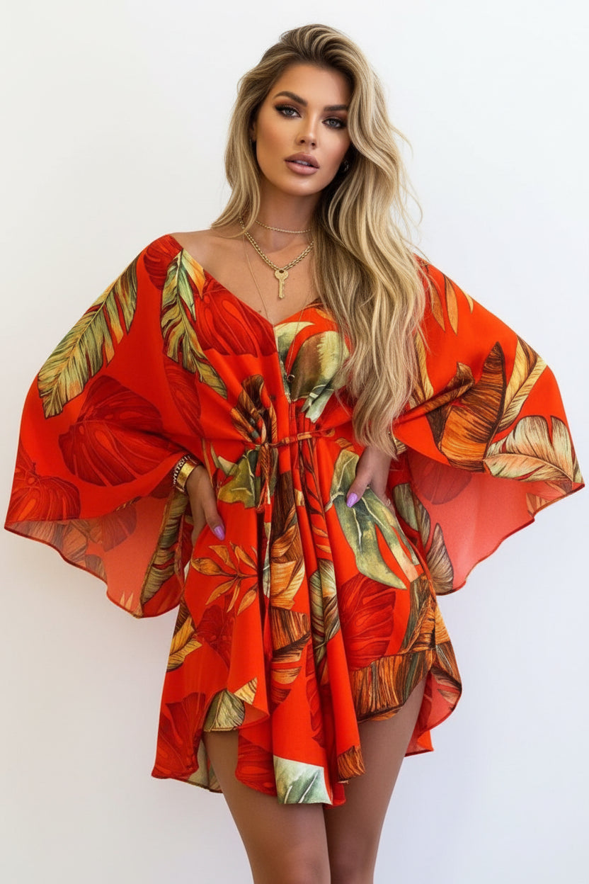 Red dress with tropical leaf pattern worn by a person on a beige background