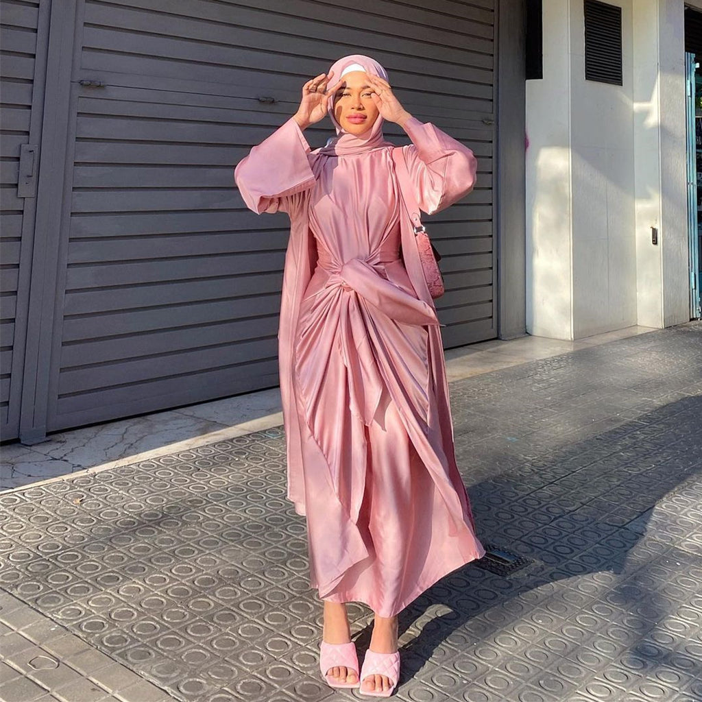 Woman in a pink outfit standing in front of a gray garage door.