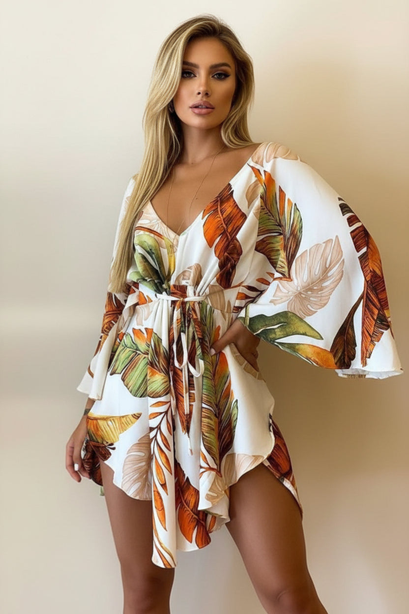 Woman wearing a tropical leaf patterned dress with a neutral background