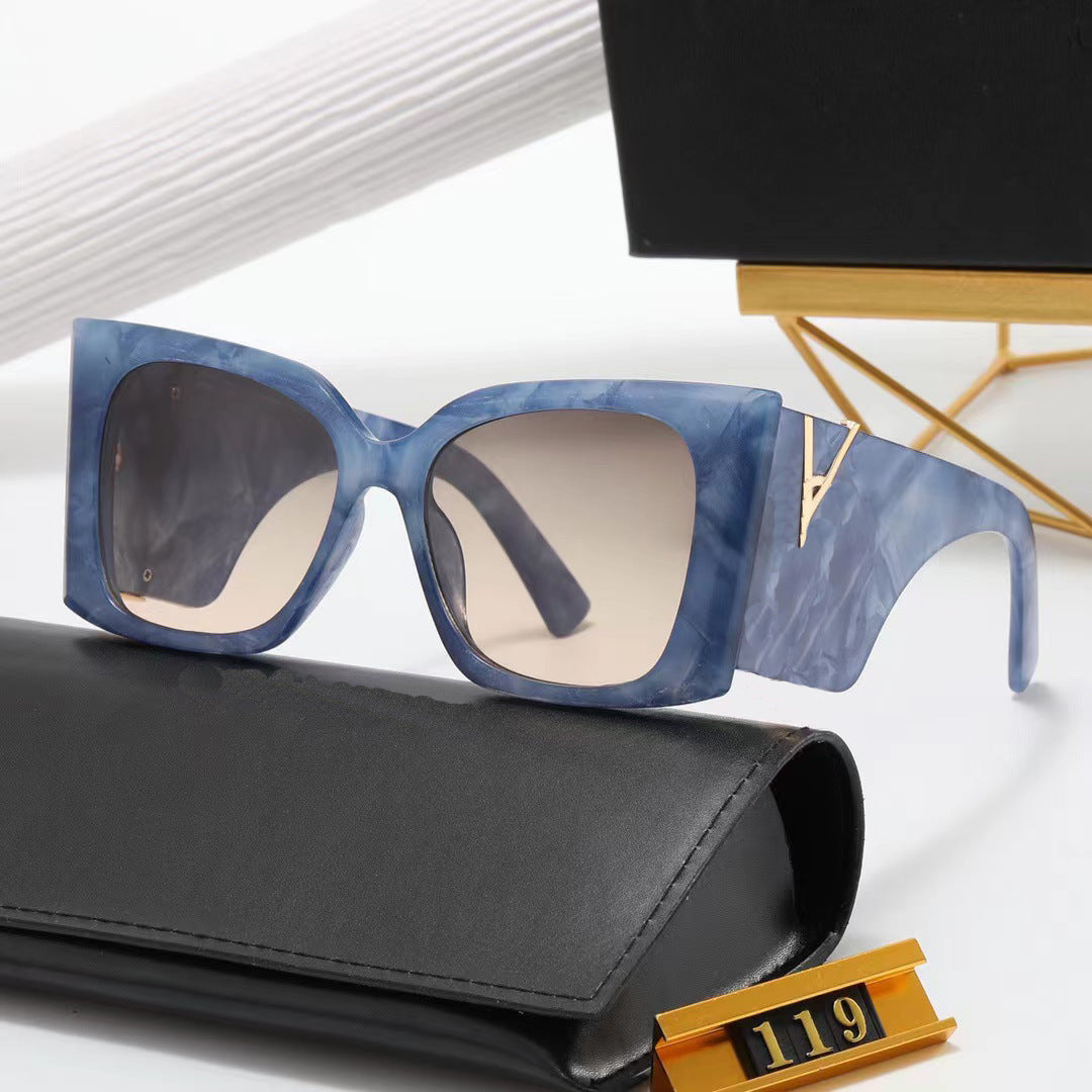 Blue sunglasses with a black case on a white surface