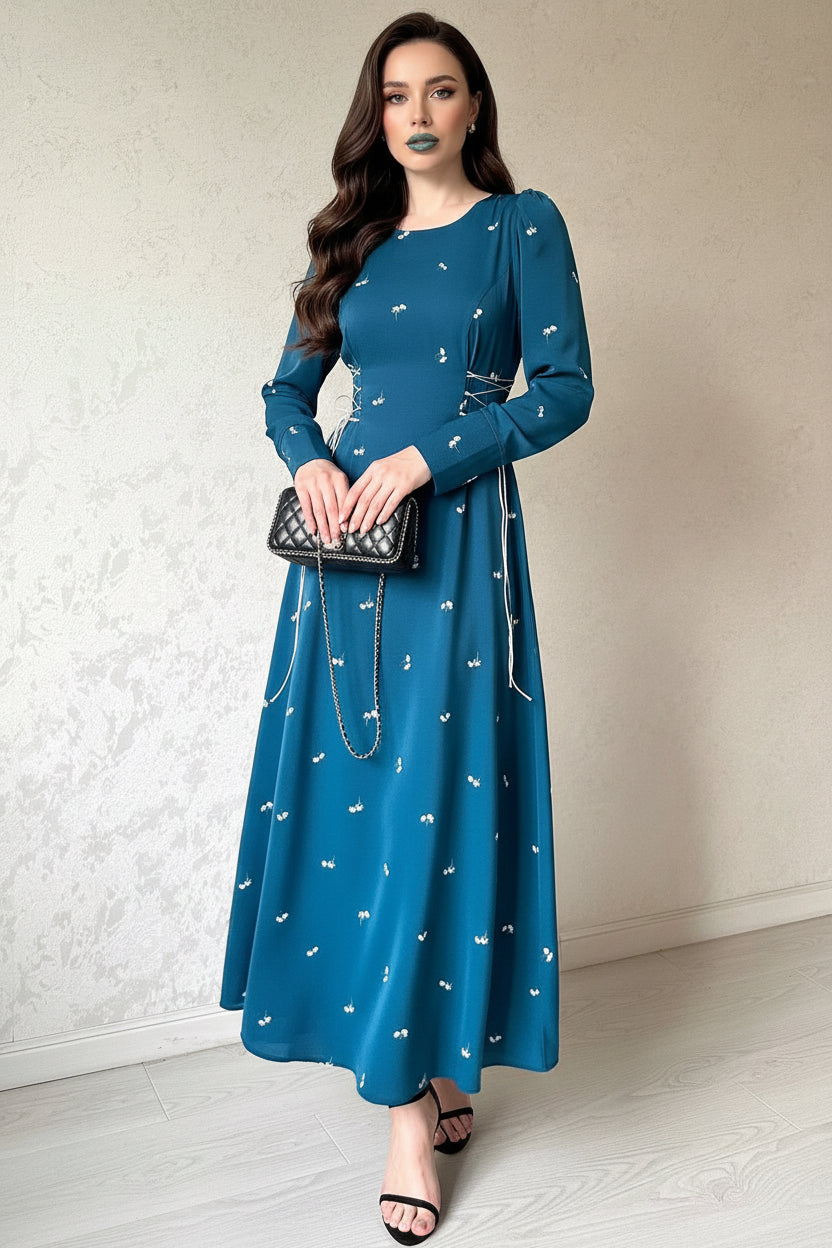 Woman wearing a blue dress with white patterns against a neutral background