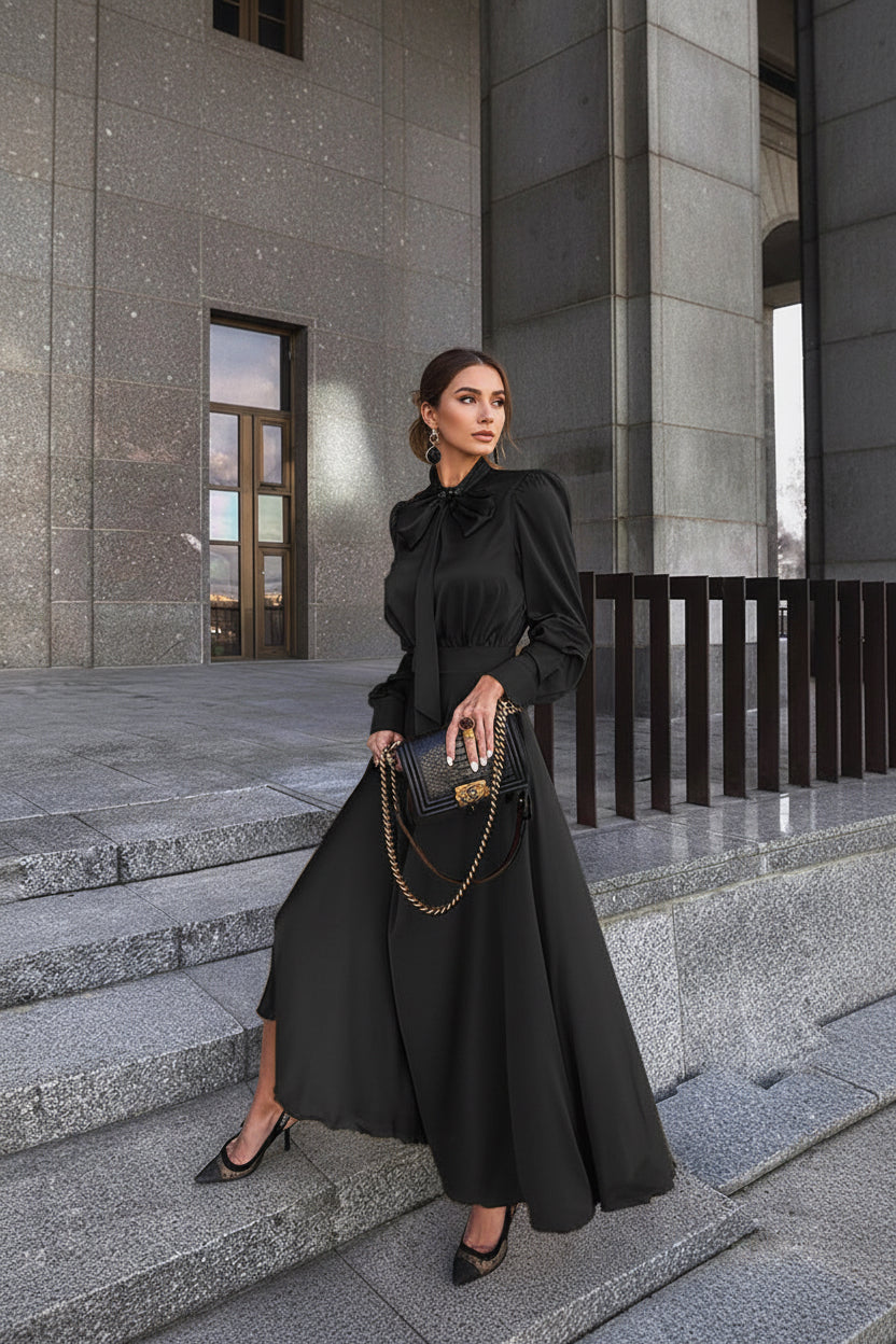 Woman in a black outfit holding a handbag on stone steps.