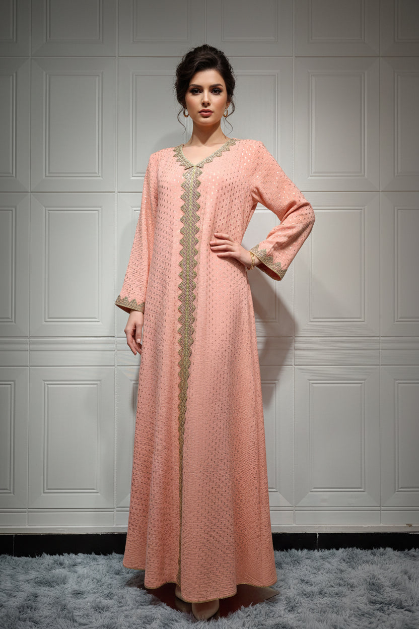 Peach-colored dress with gold embroidery on a mannequin against a white paneled wall.