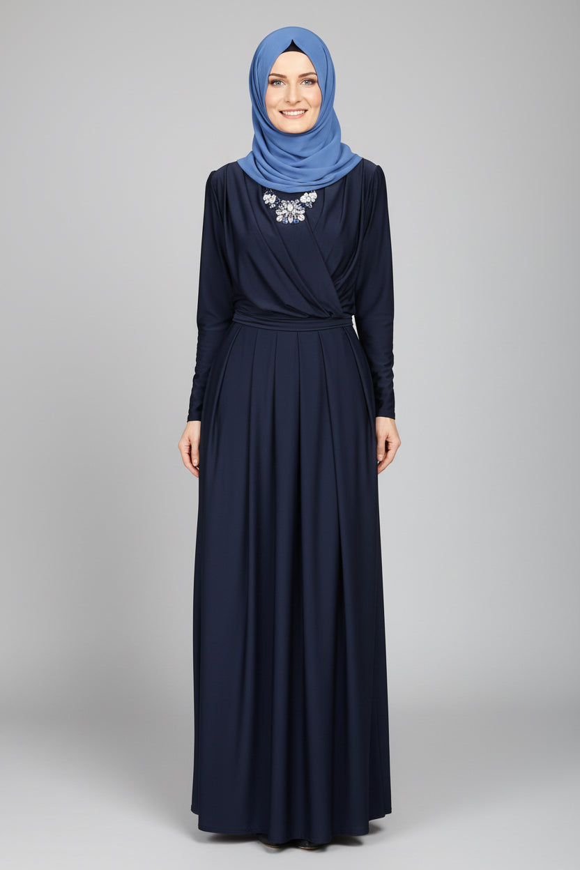 Person wearing a long dark blue dress and blue hijab standing in front of a blue door.