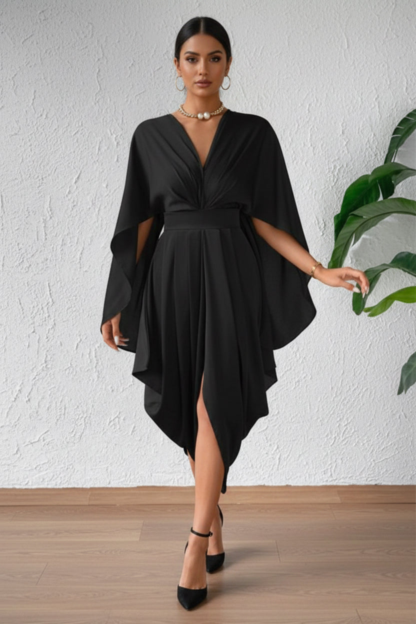 Black dress with cape sleeves worn by a person against a white wall.