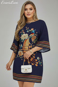 Navy blue dress with peacock and floral embroidery held by a person.